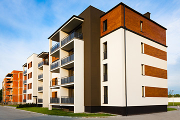 New block of apartment buildings stand in uninhabited suburb.