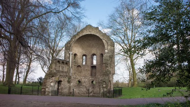 People passing by the ruins of a monumental chapel in an urban park, 4K time lapse