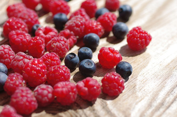 Juicy mature berries of  raspberry and bilberry  close up. Berry background