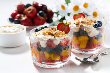 Assorted fresh fruit with custard on white table, closeup