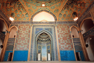Empty space of ancient mosque with artistic tiles and ceilings in Iran