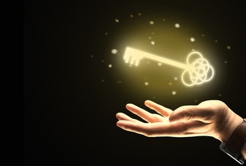 Businessman hand holding golden key