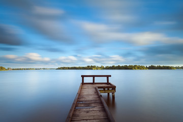wooden pier on big lake with long exposure