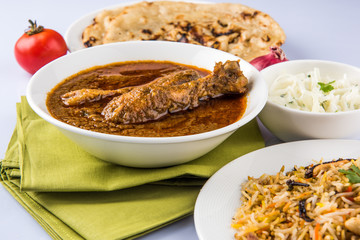 The most popular reddish chicken curry in the UK, india, pakistan, asia, chicken tikka masala, here served in bowl, accompanied by pilau rice and chapatis. © StockImageFactory