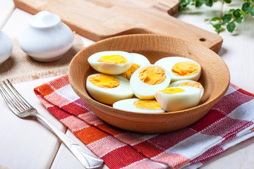 Half-boiled eggs in a wooden bowl.