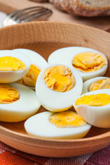 Half-boiled eggs in a wooden bowl.