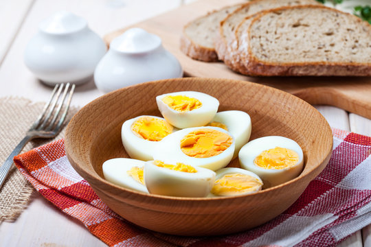 Half-boiled eggs in a wooden bowl.