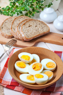 Half-boiled eggs in a wooden bowl.