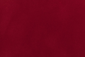 Dark red suede fabric closeup. Velvet texture.