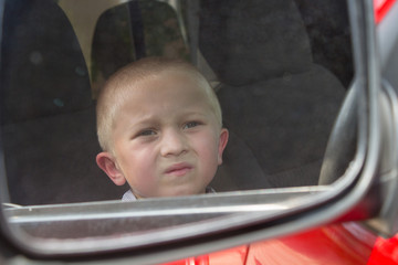 Boy in car mirror