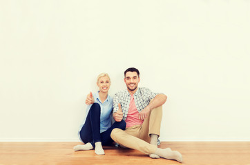 Fototapeta premium happy couple showing thumbs up at new home