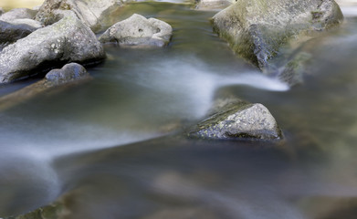 Fototapeta na wymiar The river - flowing water between the rocks.