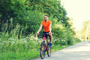 Fototapeta na wymiar happy young man riding bicycle outdoors