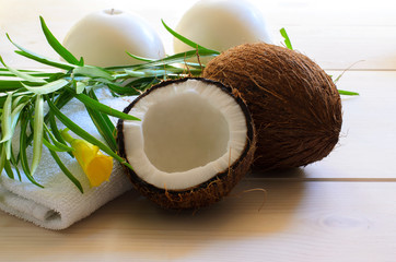 Coconut, towel towel with tropical flower and candles on light wood background for  spa concept.