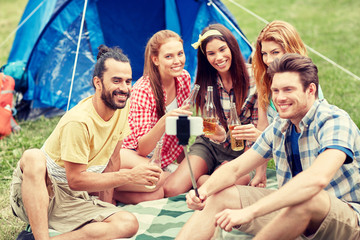 happy friends taking selfie by smartphone at camp