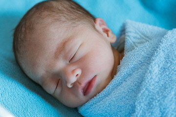 Newborn baby Asia  while sleeping covered with blue cloth