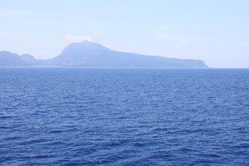 View of the island of Capri from the Tyrrhenian Sea in clear weather. Campania, Italy.