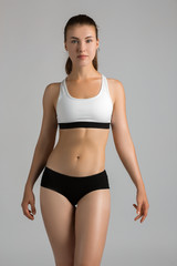 Fototapeta premium Female fitness Model posing on grey