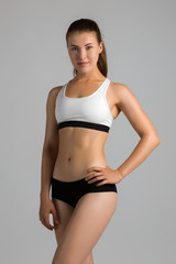 Fototapeta premium The body sports an attractive woman on a gray background