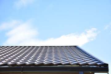 black roof tiles on house with blue sky