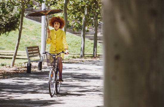 Redhaired beauty woman fashion girl on bicycle with chinesse umb
