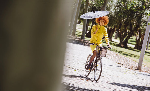 Redhaired beauty woman fashion girl on bicycle with chinesse umb