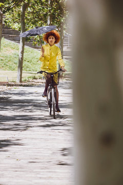 Redhaired beauty woman fashion girl on bicycle with chinesse umb