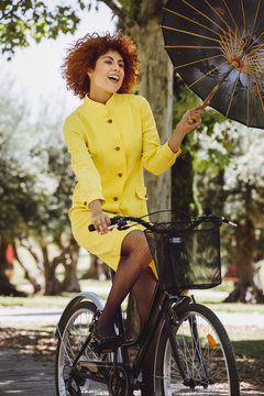 Redhaired beauty woman fashion girl on bicycle with chinesse umb