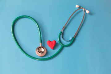 Red heart and a stethoscope on blue background