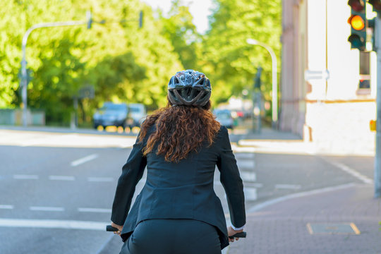 Woman Cycling To Work In A City