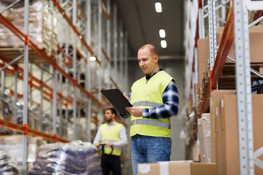 man with clipboard in safety vest at warehouse