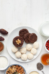 Raw vegan paleo style cookies selection, made with nuts, coconut oil, honey and dates, top view, selective focus on walnut
