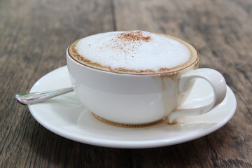 A cup of hot cappuccino on table.