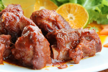 Chinese sweet and sour pork ribs on white plate.