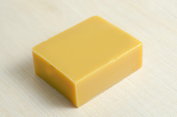 Soap bar flavor with mango ingredient isolated on wooden board b