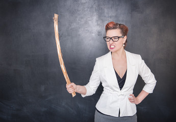 Angry screaming teacher with wooden stick on blackboard backgrou