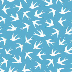 Seamless pattern with a flock of swallows. Vintage background of silhouettes of birds in the sky. Vector illustration.