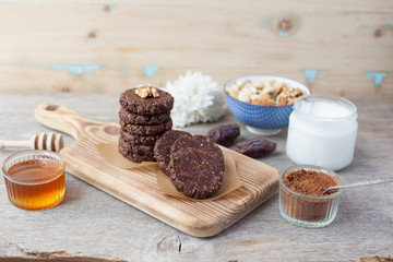 Raw vegan paleo style cookies, made with nuts, coconut oil, honey and dates, selective focus on the nearest cookie