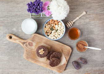 Raw vegan paleo style cookies, made with nuts, coconut oil, honey and dates, selective focus on the walnut on the cookie, top view