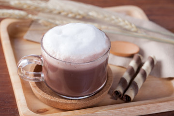 close up hot chocolate milk with snack on wooden plate on wooden