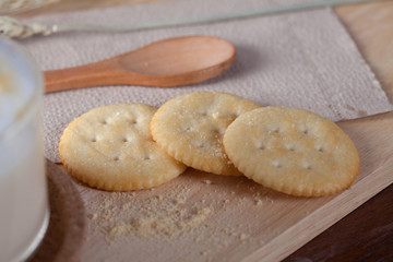 close up biscuits with hot milk on wooden plate on wooden table