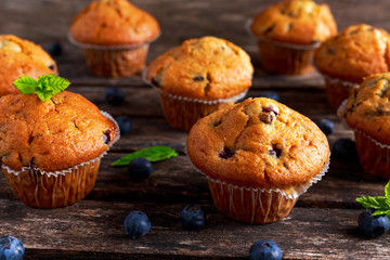 Homemade Blueberry Muffins with fresh berries on wooden table.