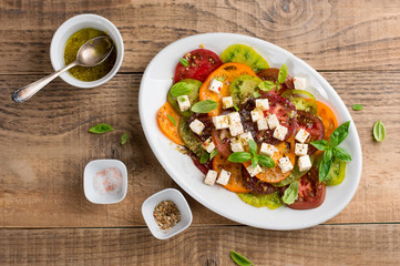 Salad with colorful tomatoes with cheese and pesto, selective focus