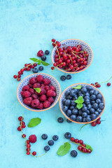 Fresh raspberries, blueberries and red currants in bowls