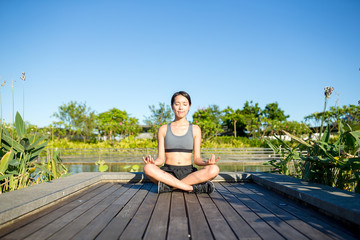 Woman sitting in yoga pose at park