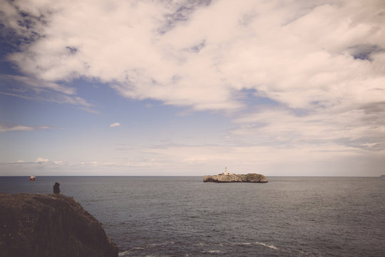 Photographer taking pictures of a lighthouse on an island