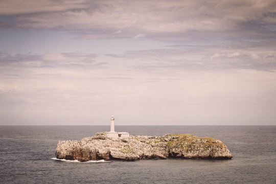 Lighthouse over rocks on an island, Spain