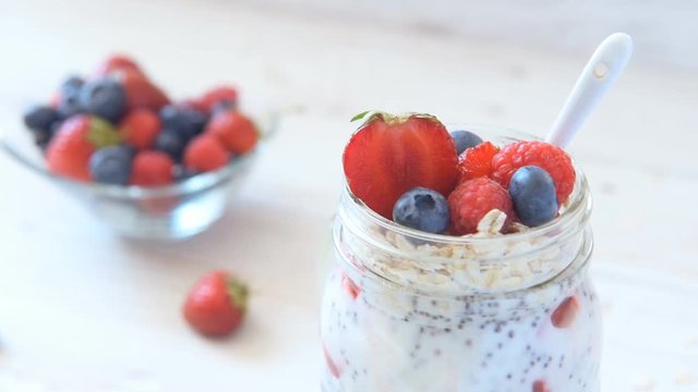 Chia seeds pudding with berries in jar on wooden table. Vegetarian concept.