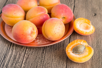 Ripe juicy apricots.   Ripe juicy apricots on a round copper tray on a wooden table.