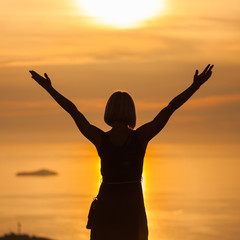 Female tourist standing on the background of Bay at sunset. Misty layers of islands. Sunset in Adriatic sea with layers mountains on the horizon. Hills, growing out of the water. Dubrovnik. Croatia.